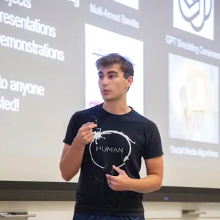 Evan Doubek presenting in front of a projected slide