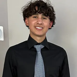 Nate Levkov smiling in a black shirt and tie