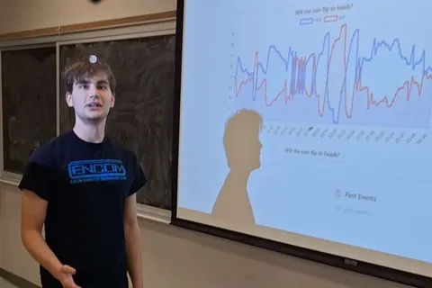 A SIGecom member presenting a live YES/NO prediction chart from Predictions Lab