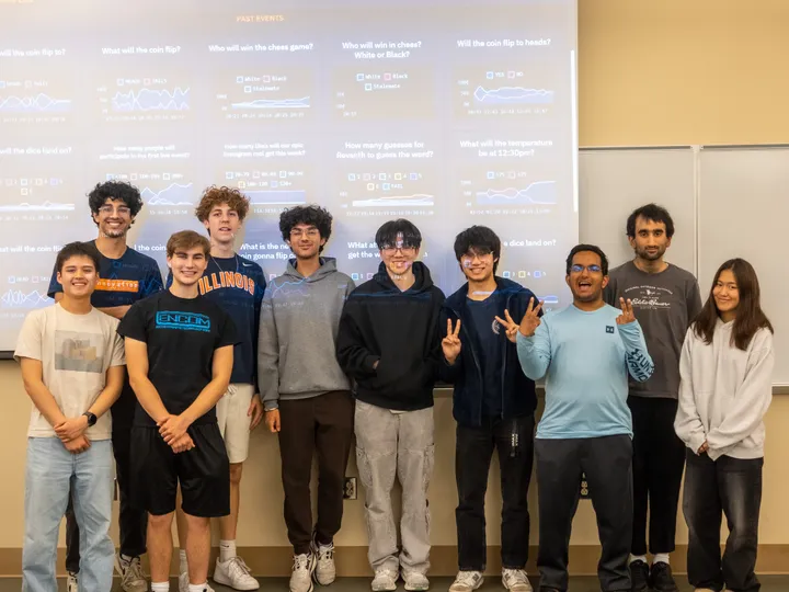 SIGecom members posing together in front of a Predictions Lab presentation slide